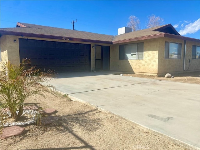 single story home with stucco siding, an attached garage, concrete driveway, and a shingled roof