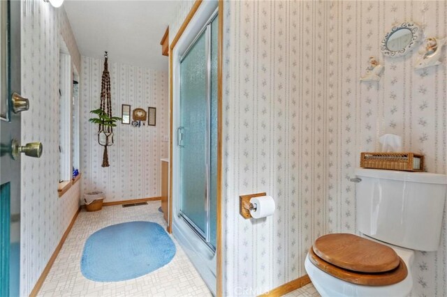 bathroom with walk in shower, tile patterned floors, and toilet