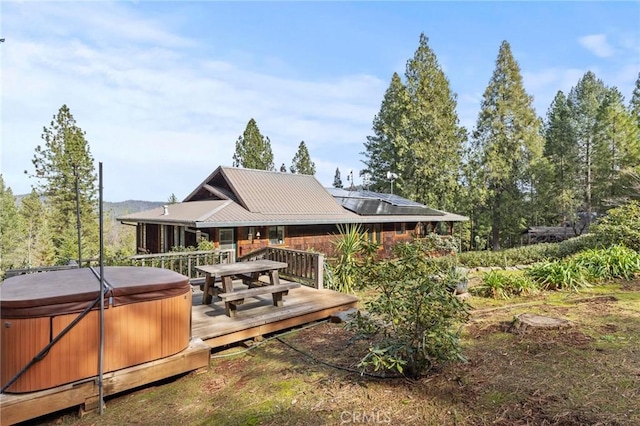 exterior space with a hot tub and a deck