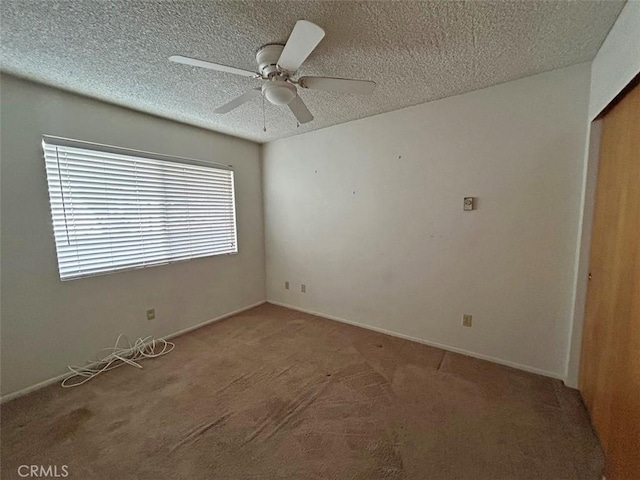 spare room with ceiling fan, carpet, and a textured ceiling