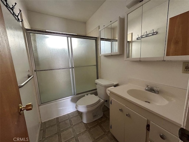 full bathroom with enclosed tub / shower combo, vanity, and toilet