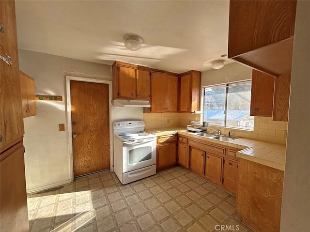 kitchen with white electric stove, sink, tile counters, and backsplash