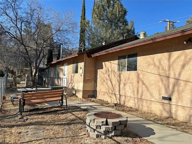 view of home's exterior featuring an outdoor fire pit