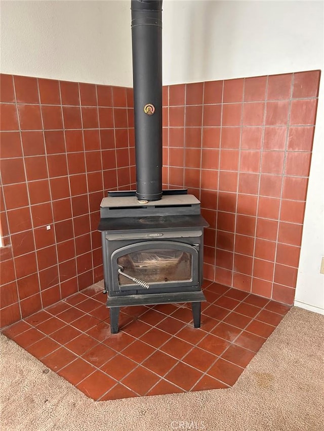 room details featuring carpet flooring and a wood stove