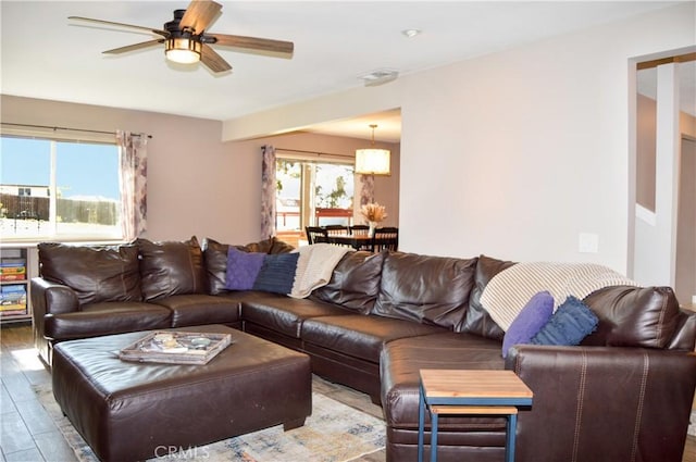 living area with a ceiling fan and wood finished floors