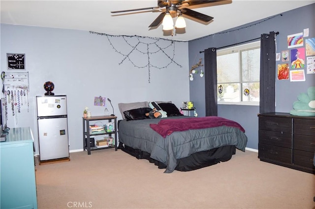bedroom with carpet floors, baseboards, freestanding refrigerator, and a ceiling fan