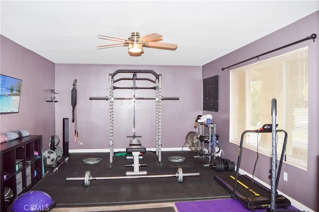workout area featuring baseboards and a ceiling fan