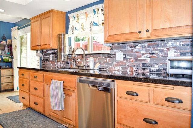 kitchen with stainless steel dishwasher, a sink, decorative backsplash, and light tile patterned floors