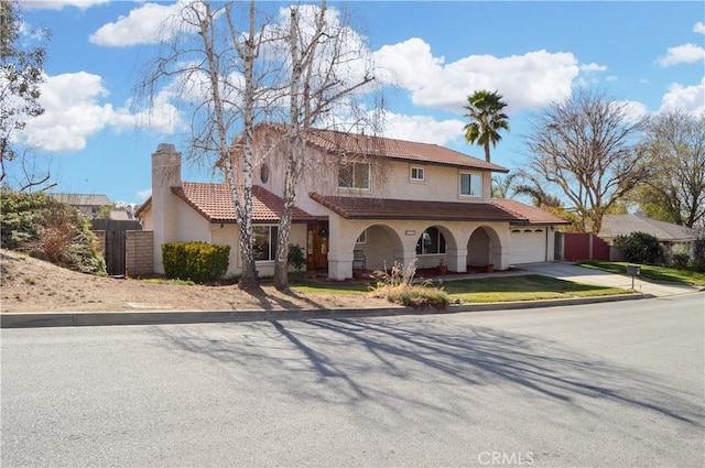 view of front of house with concrete driveway, an attached garage, fence, and stucco siding