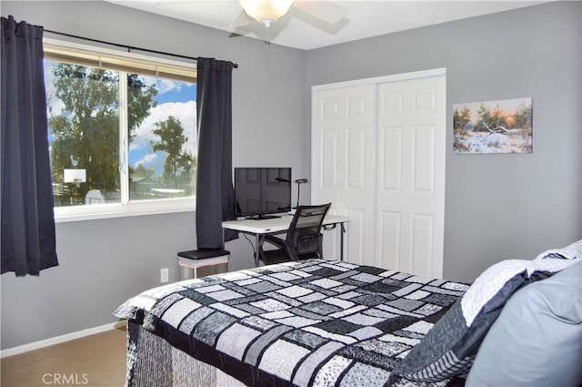 carpeted bedroom featuring a closet, a ceiling fan, and baseboards
