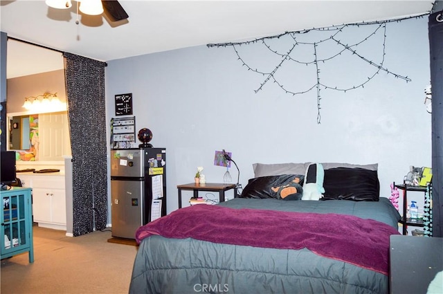 bedroom featuring freestanding refrigerator and light carpet