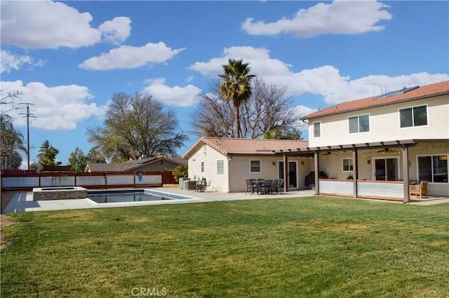 rear view of property with a tiled roof, a patio area, a fenced backyard, a yard, and stucco siding