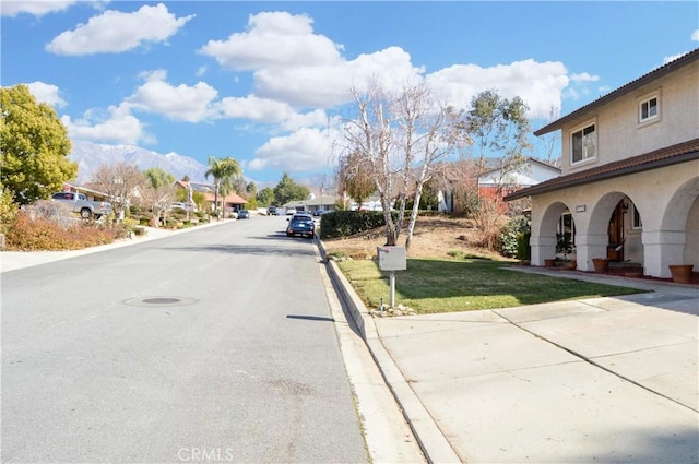 view of road with a residential view and curbs