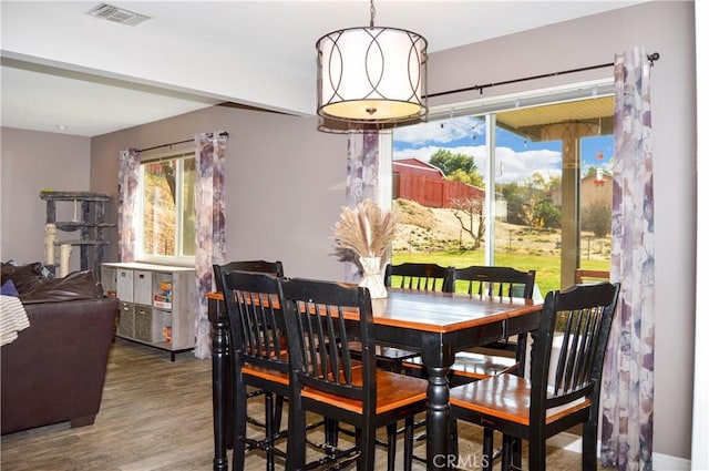 dining area with visible vents and wood finished floors