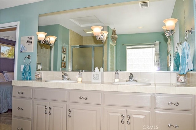 bathroom with a sink, ensuite bathroom, a shower stall, and visible vents