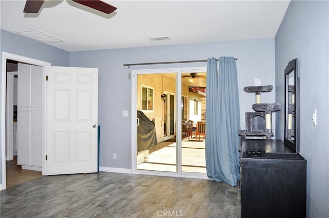interior space with ceiling fan, visible vents, and wood finished floors