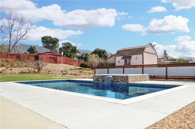 view of swimming pool with an outdoor structure, fence, a fenced in pool, a patio area, and a mountain view