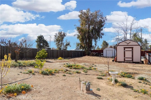 view of yard with a storage unit, a fenced backyard, and an outbuilding