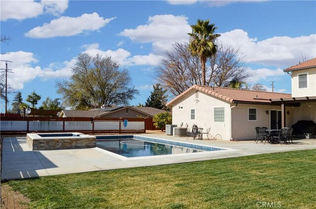 view of swimming pool with fence, a patio, a fenced in pool, an in ground hot tub, and a yard