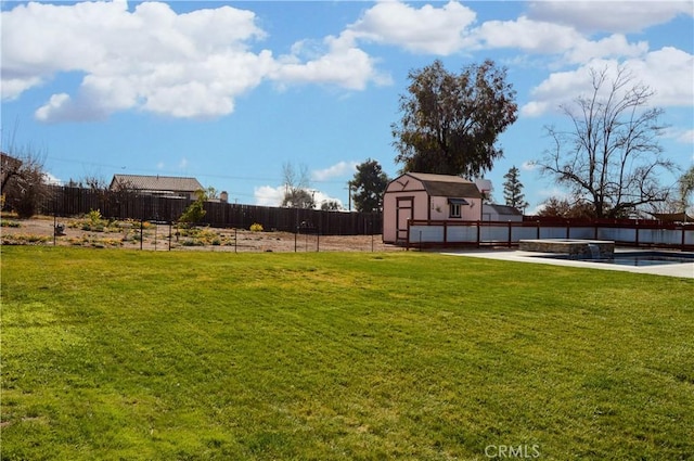 view of yard with a storage shed, fence, and an outdoor structure