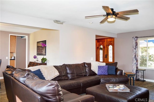 living room featuring baseboards, a ceiling fan, dark wood finished floors, and visible vents