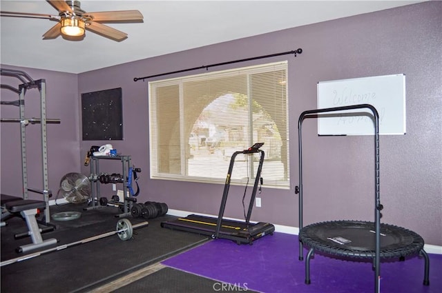 workout area with a ceiling fan and baseboards