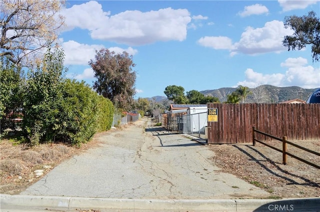 view of street with a mountain view and a gate