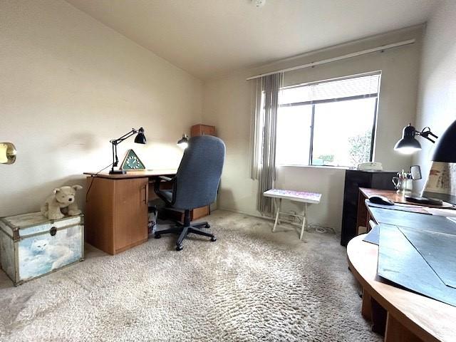 office area featuring lofted ceiling and light colored carpet