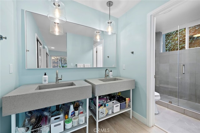 bathroom featuring walk in shower, toilet, sink, and hardwood / wood-style floors