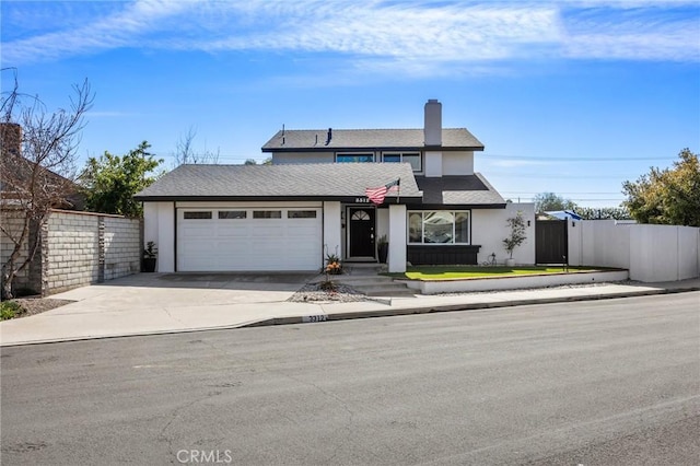 traditional-style home with fence, driveway, an attached garage, and stucco siding