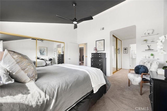 carpeted bedroom with visible vents, ceiling fan, and a high ceiling