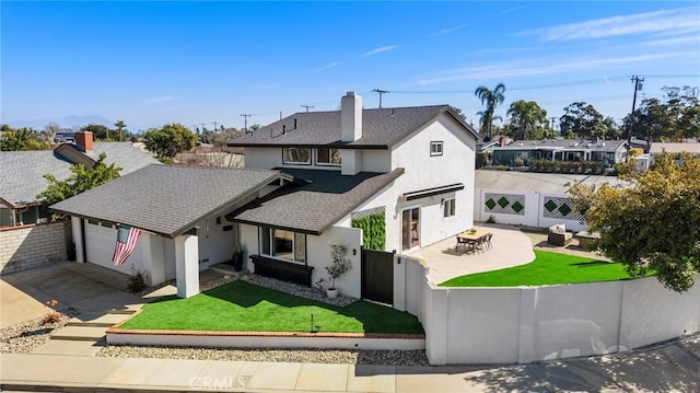 view of front facade featuring a garage, a fenced backyard, driveway, and a front lawn