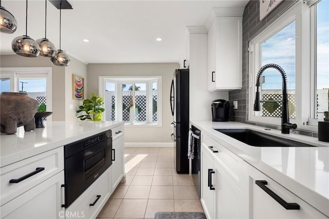 kitchen featuring a healthy amount of sunlight, a sink, black appliances, and light tile patterned flooring