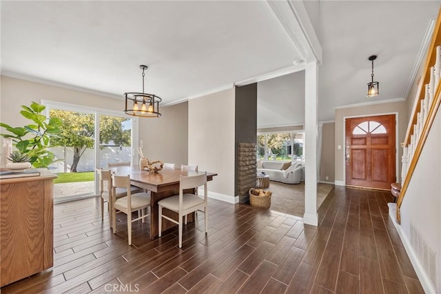 dining space with crown molding, visible vents, and wood tiled floor