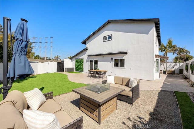 back of house featuring a patio, a gate, an outdoor living space, and stucco siding