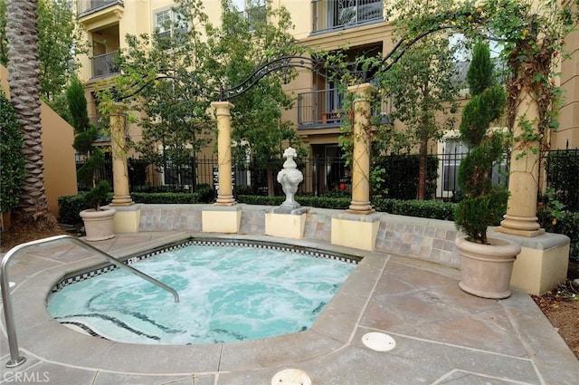 view of pool featuring fence and a community hot tub