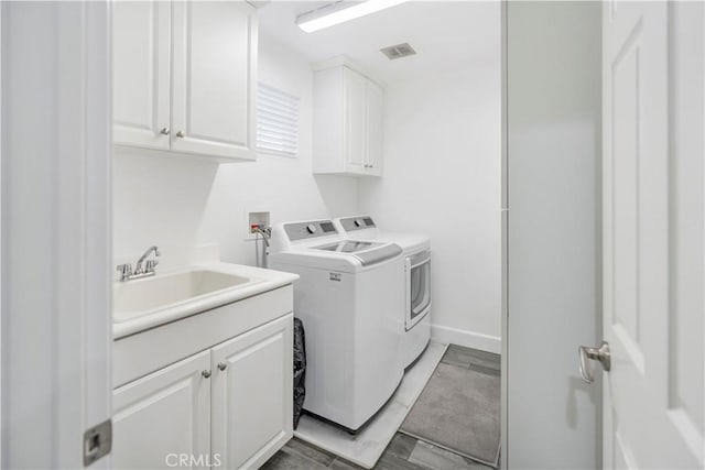 washroom featuring separate washer and dryer, sink, dark hardwood / wood-style floors, and cabinets