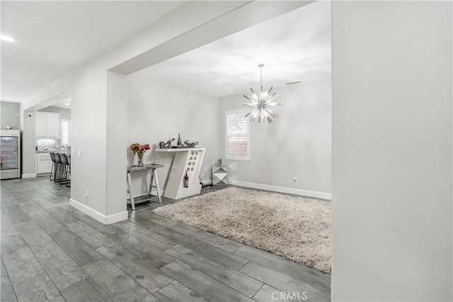 interior space featuring a wealth of natural light, hardwood / wood-style floors, and a notable chandelier