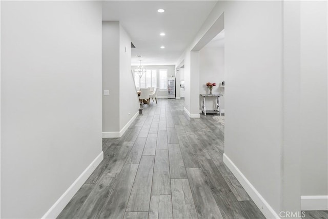 hall with hardwood / wood-style flooring and a chandelier