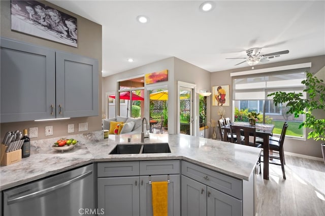 kitchen with dishwasher, a peninsula, gray cabinets, light wood-type flooring, and a sink