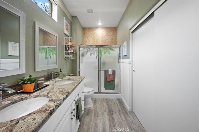 bathroom with a stall shower, visible vents, a sink, and toilet