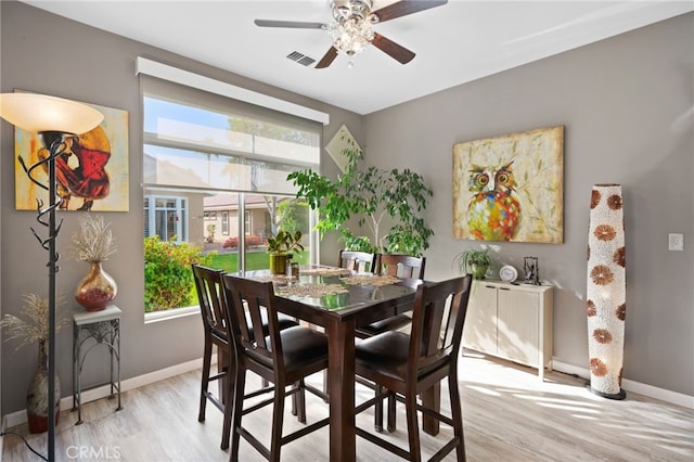 dining space with light wood-style floors, visible vents, baseboards, and a ceiling fan