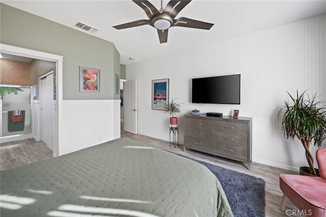 bedroom with light wood-style floors, visible vents, and a ceiling fan