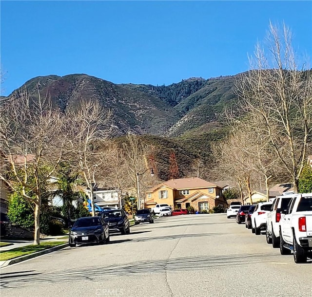 view of street with curbs, a mountain view, and sidewalks