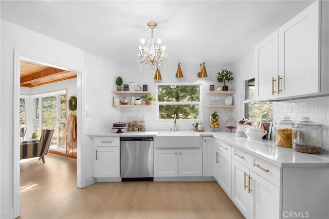 kitchen with decorative light fixtures, white cabinetry, dishwasher, sink, and backsplash