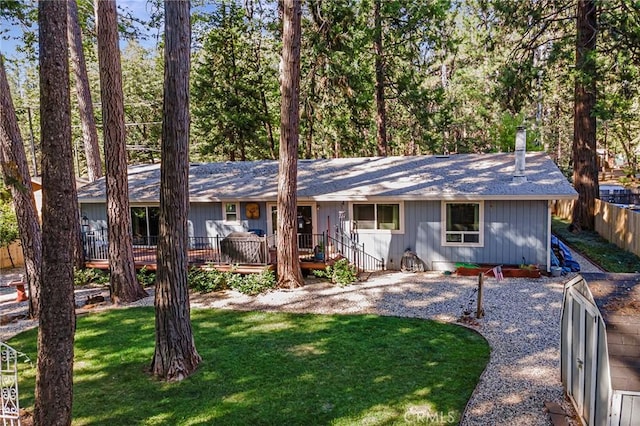 ranch-style house featuring a wooden deck and a front yard