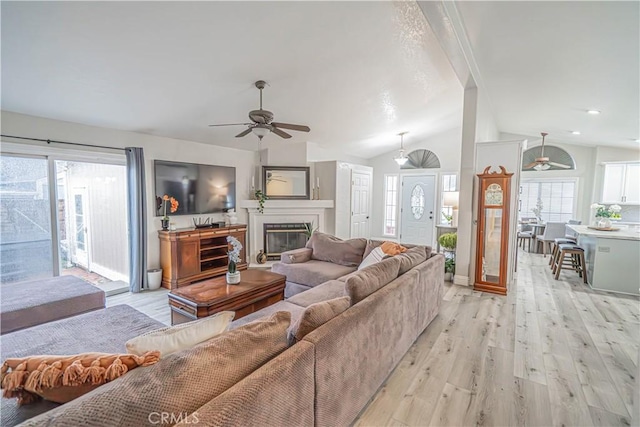 living room with lofted ceiling, light hardwood / wood-style floors, and ceiling fan