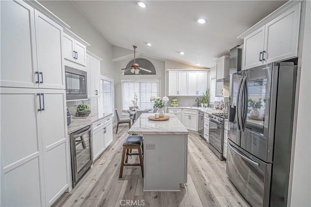 kitchen with stainless steel appliances, a center island, and white cabinets