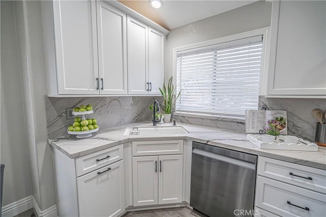 kitchen with tasteful backsplash, sink, stainless steel dishwasher, and white cabinets