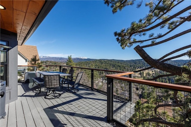 wooden deck featuring a mountain view and outdoor dining space